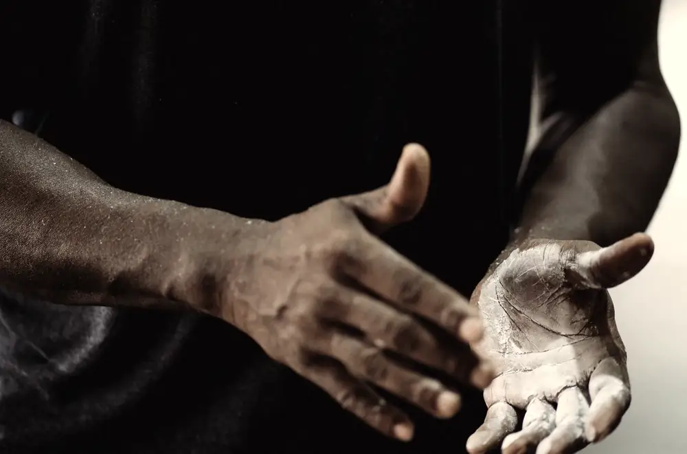 A lifter claps chalk onto both hands